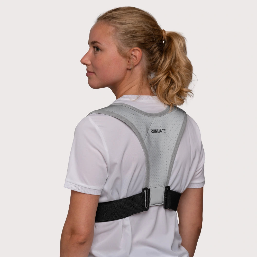 Dette er et billede af en kvinde i en refleks løbevest fra RUNMATE set bagfra