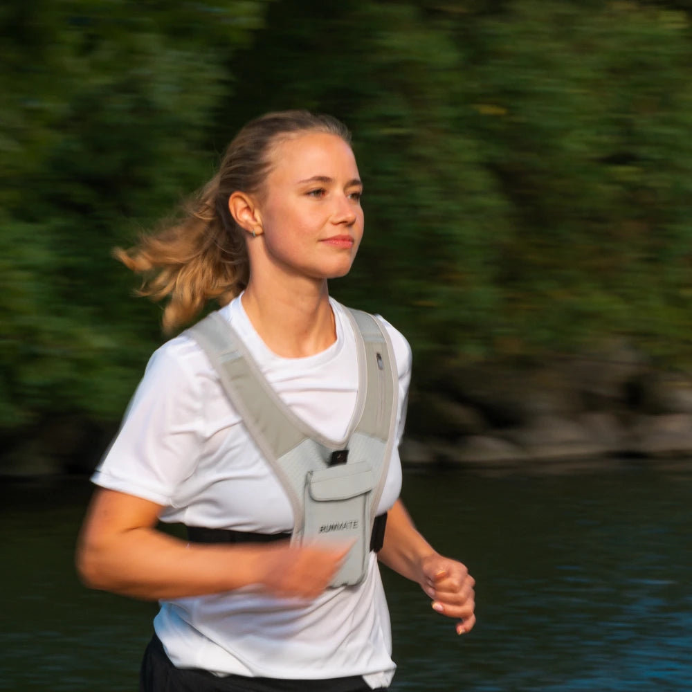 Dette er et billede af en kvinde i en refleks løbevest fra RUNMATE der løber